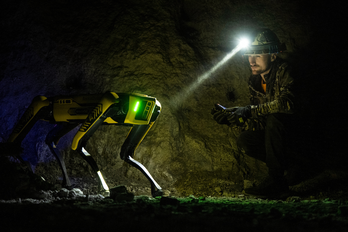 Zeb Whitehouse, an engineering technician, poses with Spot®, a robot from Boston Dynamics, is used by the Mining and Explosives Engineering department